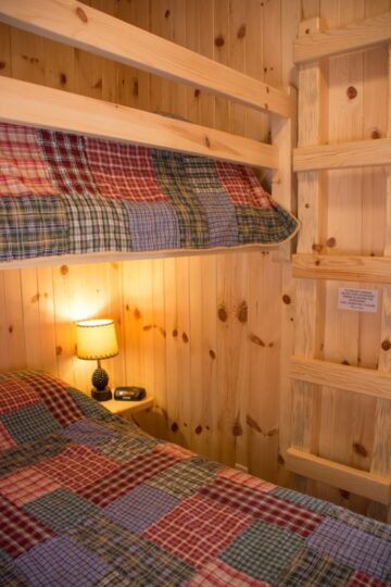 Cozy wooden bunk bed with plaid bedding