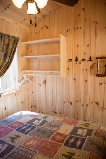 Cozy wooden cabin bedroom with patchwork quilt