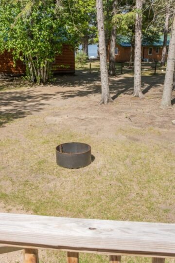 Fire pit near lakeside wooden cabins