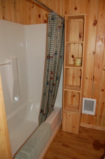 Small bathroom with bathtub and wooden panel walls
