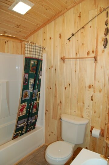 Rustic bathroom with wood-paneled walls and bathtub