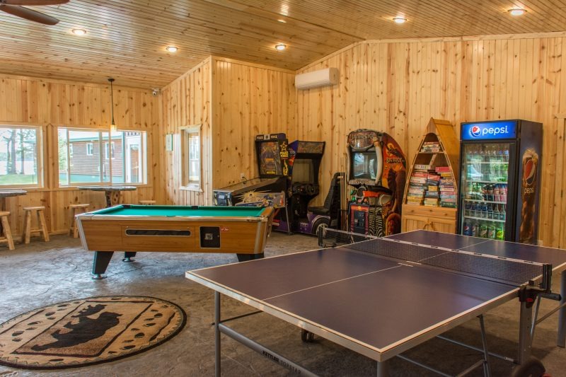 Wood-paneled game room with pool and ping pong