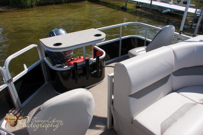 Pontoon boat interior with white seats and motor