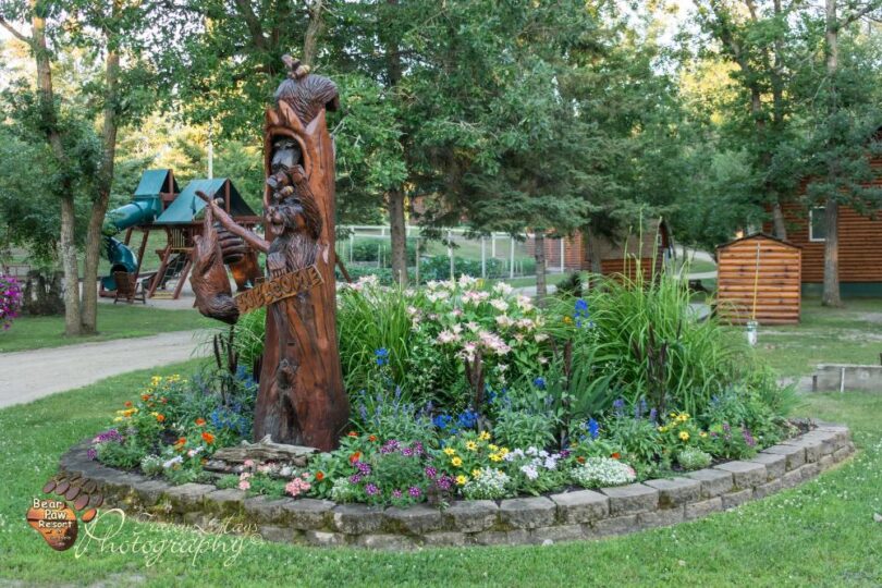 Carved wooden bear statue in flower garden